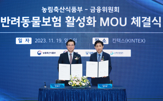 정황근(왼쪽) 농림축산식품부 장관과 김주현 금융위원장이 19일 오후 일산 서구 킨텍스 전시장에서 반려동물보험 활성화를 위한 업무협약 체결 이후 기념촬영을 하고 있다. [사진=금융위원회]